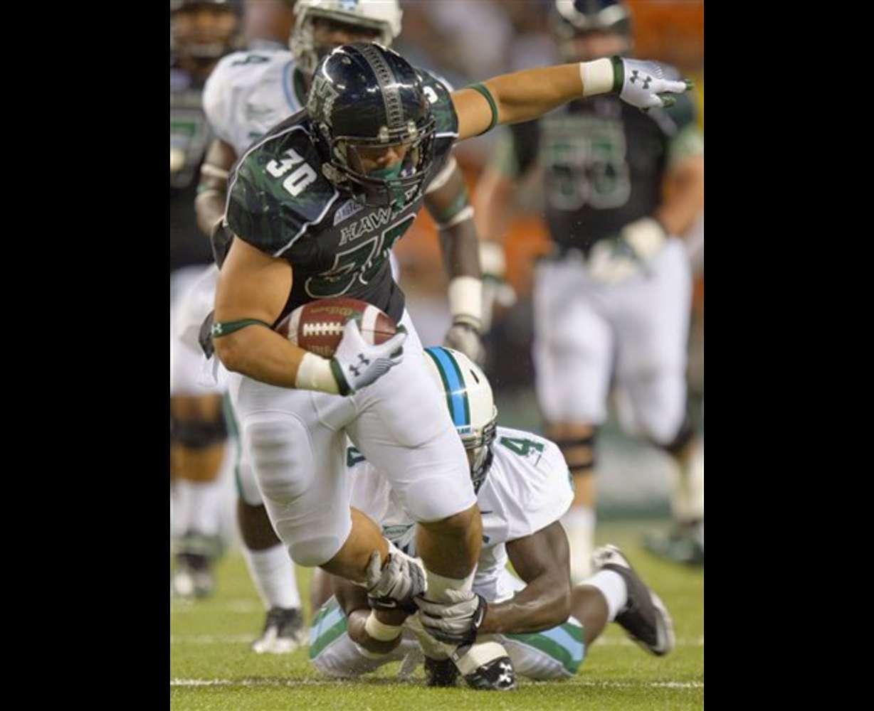 Hawaii running back Joey Iosefa (30) is tackled
from behind by Tulane safety Shakiel Smith. (AP
Photo/Eugene Tanner)