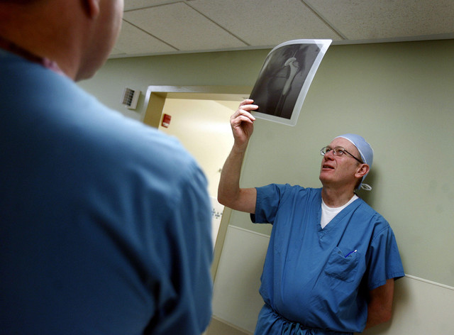 Dr. Aaron Hofmann, left, and Dr. Trevor Magee, right, check in with Sandra Jensen prior to her hip replacement surgery at Salt Lake Regional Medical Center.