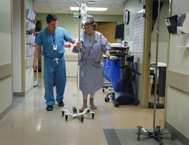 Lance Bremser, operating room technician, helps Sandra Jensen back to her room before her hip replacement surgery at Salt Lake Regional Medical Center in Salt Lake City on Friday, Dec. 2, 2011. The hospital, with Operation Walk, provided hip and knee replacements to nine Utah patients in need at no cost.