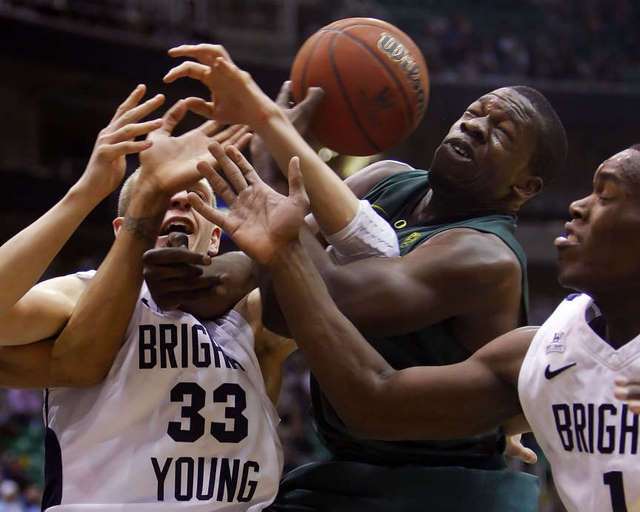 BYU's Nate Austin ,left, and teammate Charles
Abouo ,right, battle Oregon's Olu Ashaolu for
the ball. (Deseret News)