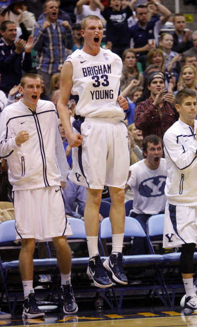 BYU's Nate Austin, center, and teammates on the 
bench celebrate a Brandon Davies dunk against 
Oregon. BYU won 79-65. (Deseret News)