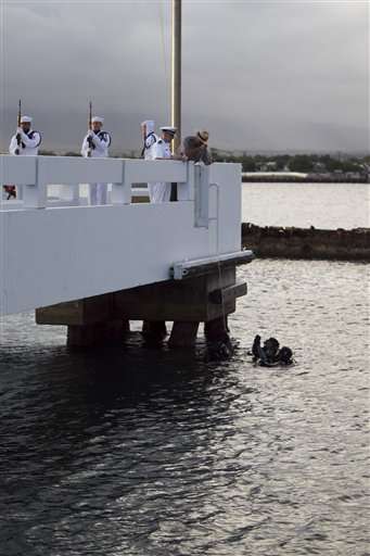 National Parks Historian Daniel Martinez, right, lowers an urn with the ashes of Pearl Harbor survivor Lee Soucy to Navy divers during Soucy's internment ceremony, Tuesday, Dec. 6, 2011 in Honolulu.