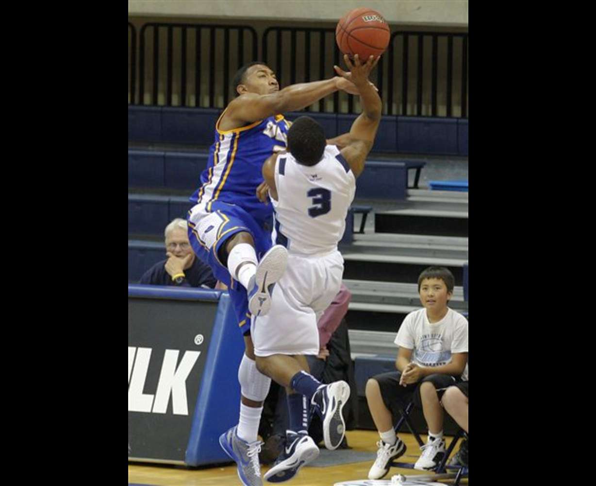 San Diego guard Darian Norris gets a shot off
against the defense of UC Santa Barbara 's
Orlando Johnson. (AP Photo/Lenny Ignelzi)