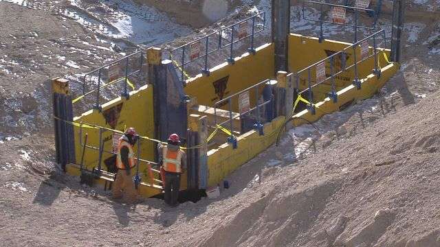 Steel lining is being lowered 20 feed below the freeway in order to reinforce what was becoming a dangerous canal.