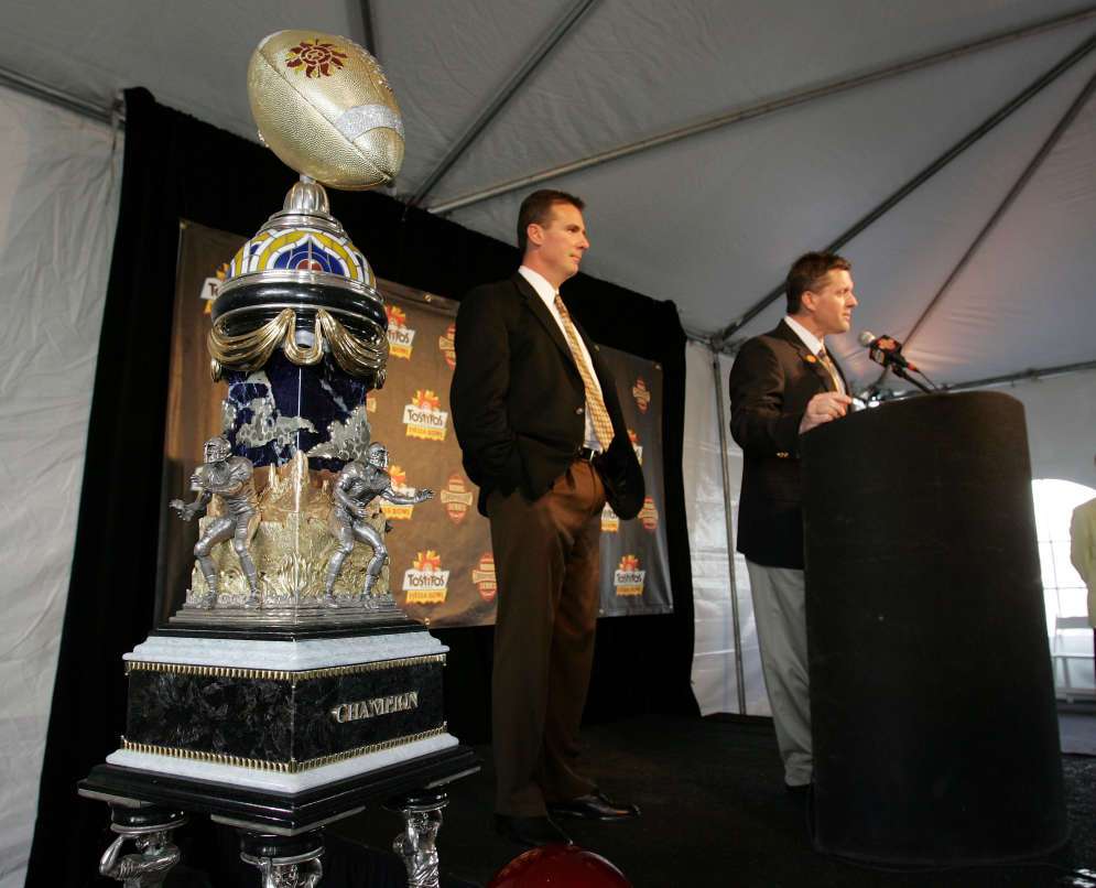 University of Utah football co-coaches Kyle Whittingham (R) and Urban Meyer speak to the media Dec 26th, 2004 at the airport in Phoenix, Arizona upon their arrival for the Fiesta Bowl. The bowl trophy was on display. (Jeffrey D. Allred, Deseret News)