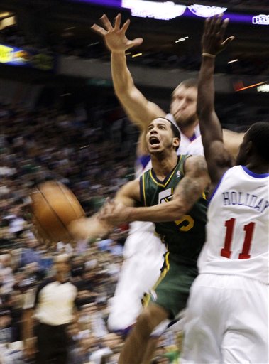 Utah Jazz guard Devin Harris (5) goes up to the
basket between Philadelphia 76ers center
Spencer Hawes (00) and guard Jrue Holiday (11).
(AP Photo/Jim Urquhart)