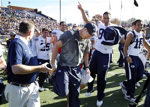 BYU head coach Bronco Mendenhall, center, celebrates with his team after defeating Tulsa 24-21 in the Armed Forces Bowl NCAA college football game, Friday, Dec. 30, 2011, in Dallas. (AP Photo/John F. Rhodes)