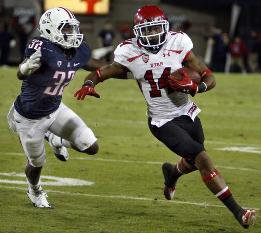 Utah's Reggie Dunn (14) outruns the reach of Arizona's Lyle Brown (32) during the second half of an NCAA college football game, in Tucson, Ariz., Saturday, Nov. 5, 2011. Utah won 34-21. (AP Photo/Wily Low)