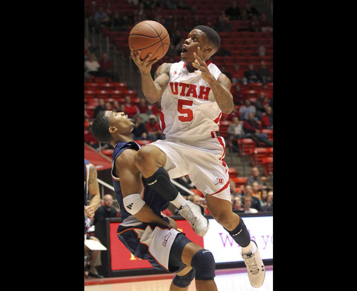 Utah guard Kareem Storey (5) is fouled by Cal State Fullerton guard Kwame Vaughn (5) during the first half of an NCAA college basketball game in Salt Lake City, Wednesday, Dec. 7, 2011. (AP Photo/Colin E Braley)