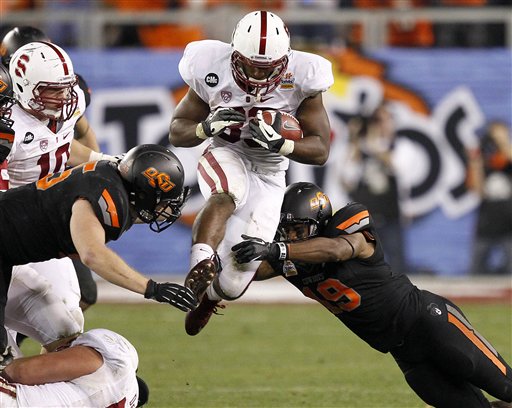 Stanford running back Stepfan Taylor, center, is tackled by Oklahoma State cornerback Brodrick Brown, right, and linebacker Caleb Lavey, left, during the second half of the Fiesta Bowl NCAA college football game Monday, Jan. 2, 2012, in Glendale, Ariz. (AP Photo/Matt York)