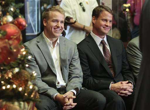 Southern California quarterback Matt Barkley, left, and head coach Lane Kiffin listen as athletic director Pat Haden speaks following Barkley's announcement that he is staying to play his senior year during an NCAA college football news conference in Los Angeles, Thursday, Dec. 22, 2011. (AP Photo/Jason Redmond)