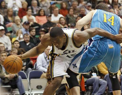 Utah Jazz's Derrick Favors, left, hooks New
Orleans' Hornets Jason Smith as he goes to the
basket during the second half of an NBA
basketball game in Salt Lake City, Monday, Jan.
2, 2012. The Jazz beat the Hornets 94-90. (AP
photo/George Frey)