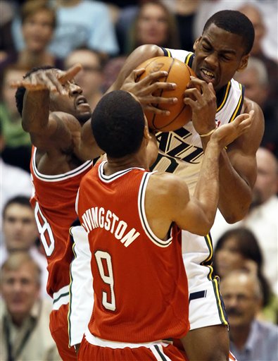 Milwaukee Bucks' Larry Sanders, left, and Shaun 
Livingston, center, fights for the ball with 
Utah Jazz's Alec Burks. (AP photo/George Frey)