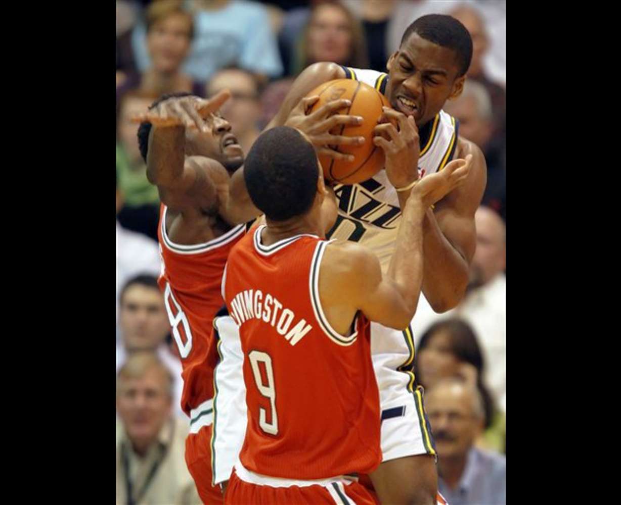Milwaukee Bucks' Larry Sanders, left, and Shaun
Livingston, center, fights for the ball with
Utah Jazz's Alec Burks. (AP photo/George Frey)
