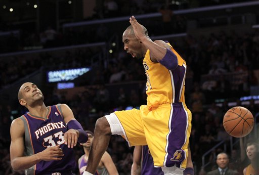 LA Lakers' Kobe Bryant descends after his dunk 
against Phoenix Suns' Grant Hill. The Lakers 
won 99-83. (AP Photo/Jae C. Hong)