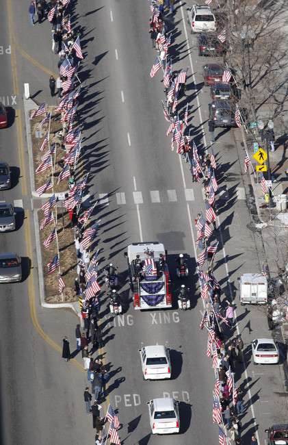 The casket of slain Ogden officer Jared Francom is placed on a fire truck and is taken along an American flag-draped route through downtown and on to the Ogden City Cemetery Wednesday, Jan. 11, 2012, in Ogden, Utah. (Photo: Tom Smart, Deseret News)