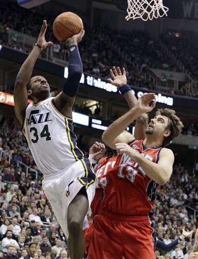 Utah Jazz forward C.J. Miles (34) shoots over 
New Jersey Nets center Mehmet Okur (13). The 
Jazz won 107-94. (AP Photo/Jim Urquhart)