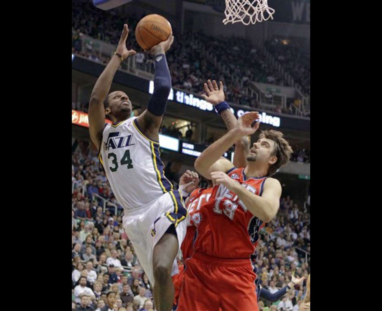 Utah Jazz forward C.J. Miles (34) shoots over
New Jersey Nets center Mehmet Okur (13). The
Jazz won 107-94. (AP Photo/Jim Urquhart)