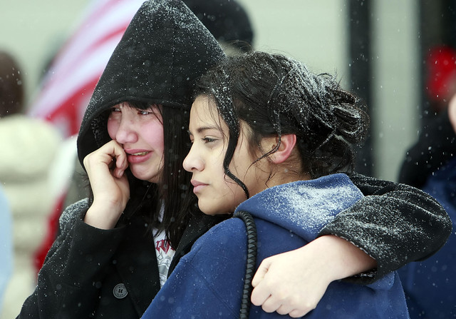 Aitana and her sister Arianna Aragon hold each other as they stand in the snow and watch their brother David leave. Family members and loved ones say goodbye to members of the Utah National Guards 211th Aviation Battalion Monday, Jan. 16, 2012 as they leave Salt Lake City Municipal 2 Airport for deployment in Afghanistan.