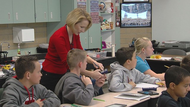 Westfield Elementary School sixth-grade teacher Karre Nevarez helps a student in her class. Thanks to a grant, her students have been using a new device called SMART Response to aid them class discussions.