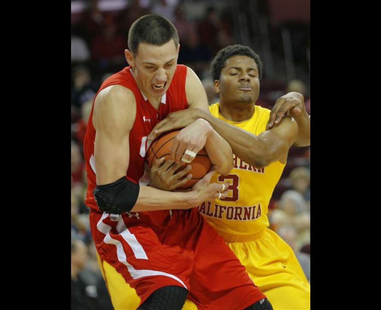 Utah's Jason Washburn, left, and USC's Alexis
Moore (3) battle for the ball. (AP
Photo/Lori Shepler)