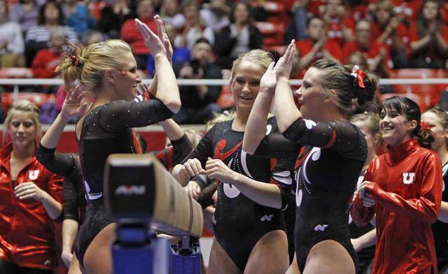 Utah's Cortni Beers, Kyndal Robarts and
Stephanie McAllister, left to rights, celebrate
after Beers' beam routine as the University of
Utah gymnasts team defeats Utah State
University. (Deseret News)