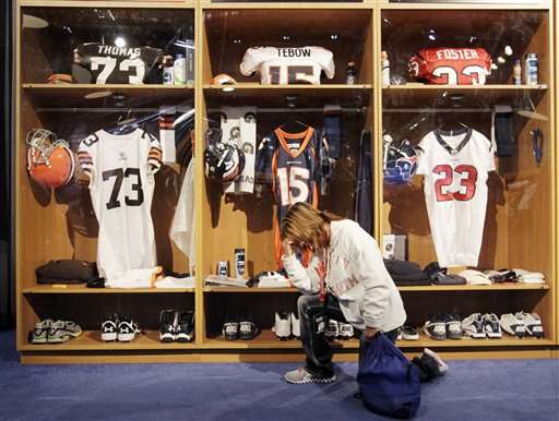 Katrina Newby, of New Castle, Ind., kneels
(Tebow's) in front of a replica of Denver
Bronco quaterback Tim Tebow's locker at the NFL
Experience. (AP Photo/Darron Cummings)
