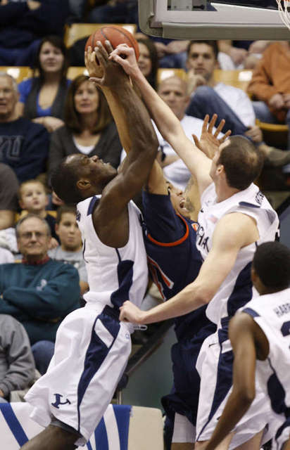 BYU's Charles Abouo, left, and Noah Hartsock
grab a rebound over Pepperdine's Hector Harold.
(Deseret News)