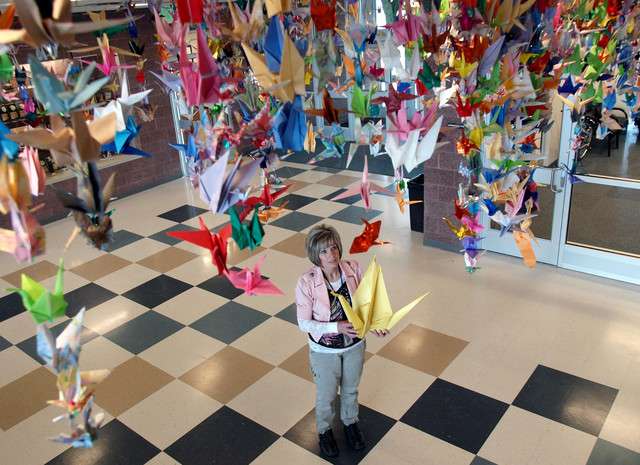 Chris Dye, an art teacher at Roosevelt Junior High School, hangs strands of paper cranes April 21, 2011. The cranes were folded by Dye's students as part of a service project that raised more than $2,500 for Japanese students following the March 11, 2011, earthquake and tsunami. (Photo: Steve Puro, Uintah Basin Standard)