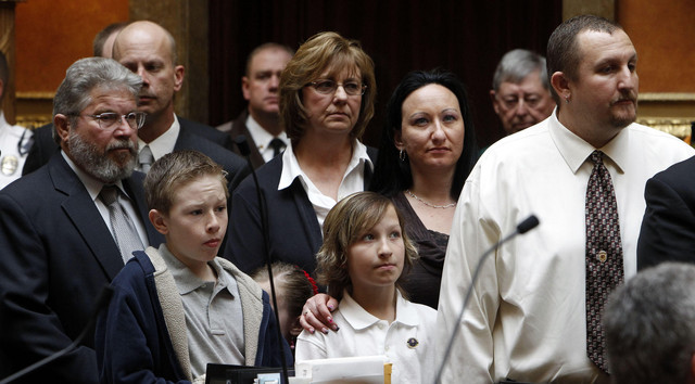 Officers and family members of officers involved in the Ogden shooting are honored in the House of Representatives at the Capitol in Salt Lake City, Wednesday, Feb. 22, 2012. At right is Nate Hutchinson, who was wounded in the shooting.