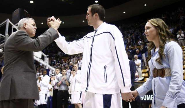 An emotional Noah Hartsock and his wife
Kendalyn are met by Head Coach Dave Rose as the
seniors are recognized. (Deseret News)