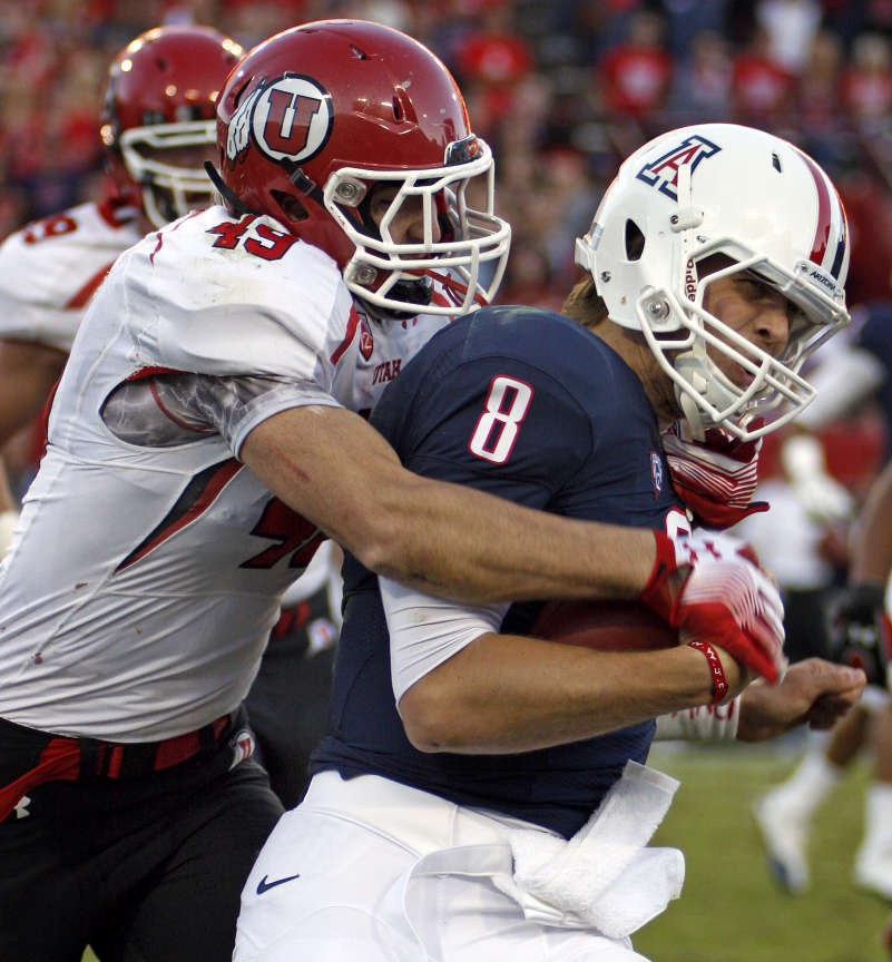 Arizona quarterback Nick Foles (8) is sacked for a loss by Utah's Trevor Reilly (49) during the first half of an NCAA college football game at in Tucson, Ariz., Saturday, Nov. 5, 2011. Utah won 34-21. (AP Photo/Wily Low)