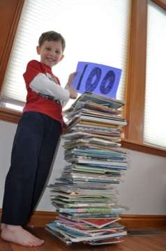 Cyndi McMillian's 5 year old poses with 100 books. McMillian read the books to the 5-year-old and to her 2-year-old in just seven days. (Photo: Cyndi McMillian)