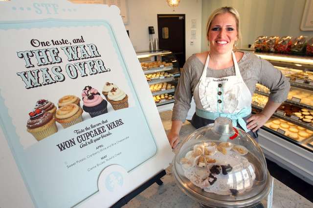 Megan Faulkner, founder of the Sweet Tooth Fairy in Salt Lake City, poses on April 9, 2012, next to a sign declaring her shop a winner of the Food Network's "Cupcake Wars."