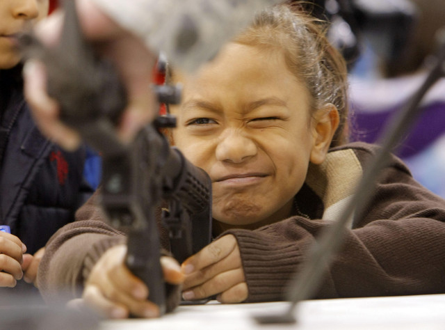 LJ Fuatogi looks into the sight of an inoperable M4 rifle as Hill Air Force Base hosts more than 700 children from local elementary schools for Kids Deployment Day Thursday, April 12, 2012.