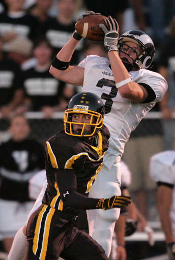 Highland's Les Brown catches the ball over Cottonwood's Stanley Havili as Highland High School plays 4a football at Cottonwood High in Salt Lake City, Utah, Oct. 7, 2005. (Tom Smart, Deseret News)