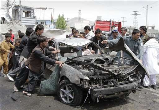 Afghans push a damaged car away from the scene of a militant attack in Kabul, Afghanistan, in May 2012. A suicide car bomber and Taliban militants disguised in burqas attacked a compound housing hundreds of foreigners in the Afghan capital officials and witnesses said. The Taliban said the attack was a response to President Barack Obama's surprise visit just hours earlier.