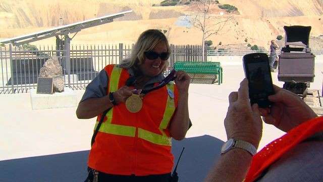 A mine employee shows off one of an Olympic medal.