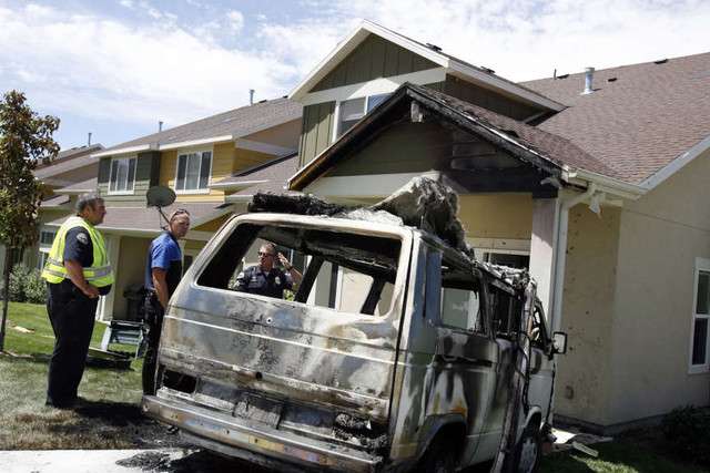 Sandy police officers inspect a Volkswagen bus that caught fire and then crashed into a Sandy home on Thursday, June 21, 2012. No one was injured.