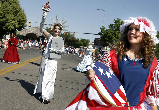 Hailey Densley, dressed as the Statue of Liberty, and Maggie Rowland as Betsy Ross, march in the Fun Days Fourth of July Parade in Murray on Wednesday, July 4, 2012.