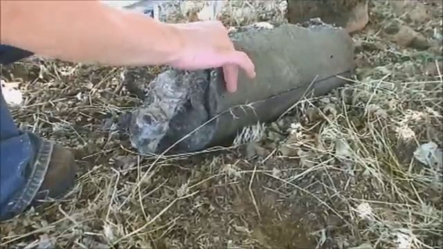 Andrew Chatwin works to free the cat from the 
concrete by carefully chiseling away at it the 
cement. (Photo: Andrew Chatwin)