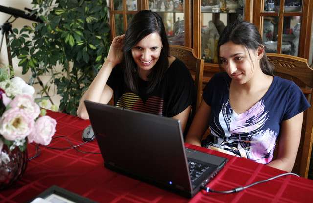 Anisa Mughal, left, and her sister Safia Mughal
watch a TV show on their computer at home in
Salt Lake City on Friday, July 13, 2012.
(Photo: Kristin Murphy, Deseret News)