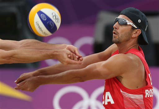 US Jake Gibb, left, and Sean Rosenthal, right, reach for a ball during their quarterfinal men's beach volleyball match against Latvia at the 2012 Summer Olympics, Monday, Aug. 6, 2012, in London.