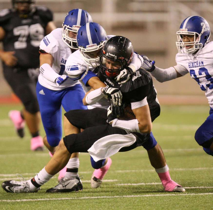 From left, Bingham's Drake Miller, Koa Wilson and Sky Manu tackle Alta's Harrison Handley a football game at the Rice-Eccles Stadium in Salt Lake City on Saturday, Aug. 25, 2012. (Kristin Murphy, Deseret News)