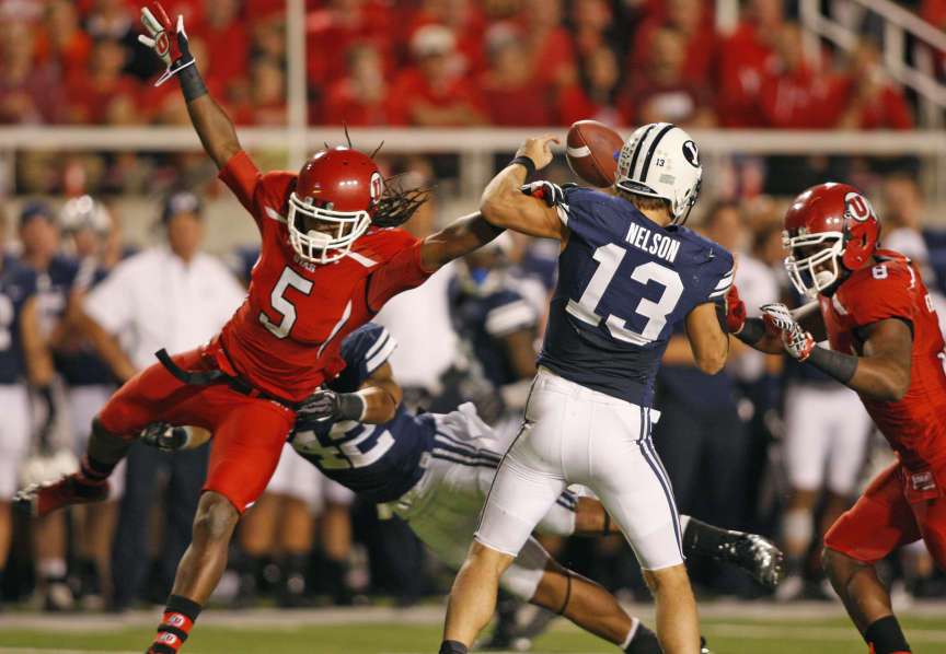 Utah Utes defensive back Mo Lee (5) knocks the ball away from Brigham Young Cougars quarterback Riley Nelson (13) in what was first called a fumble but reversed to an incomplete pass as the University of Utah and BYU play football Saturday, Sept. 15, 2012, in Salt Lake City, Utah.