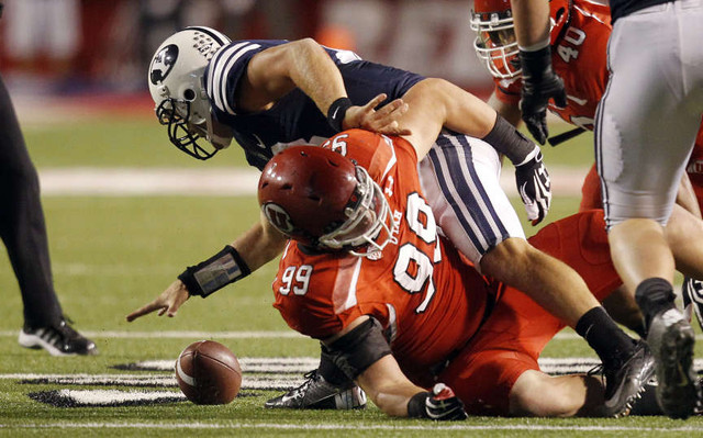 Brigham Young Cougars quarterback Riley Nelson (13) fumbles the ball as Utah Utes defensive end Joe Kruger (99) defends (Jeffrey D. Allred, Deseret News)