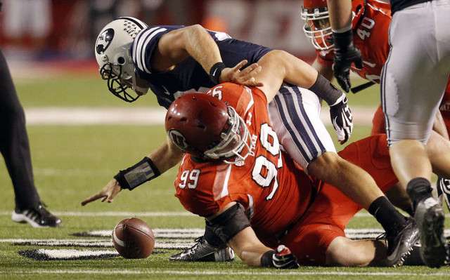 Brigham Young Cougars quarterback Riley Nelson (13) fumbles the ball as Utah Utes defensive end Joe Kruger (99) defends (Jeffrey D. Allred, Deseret News)
