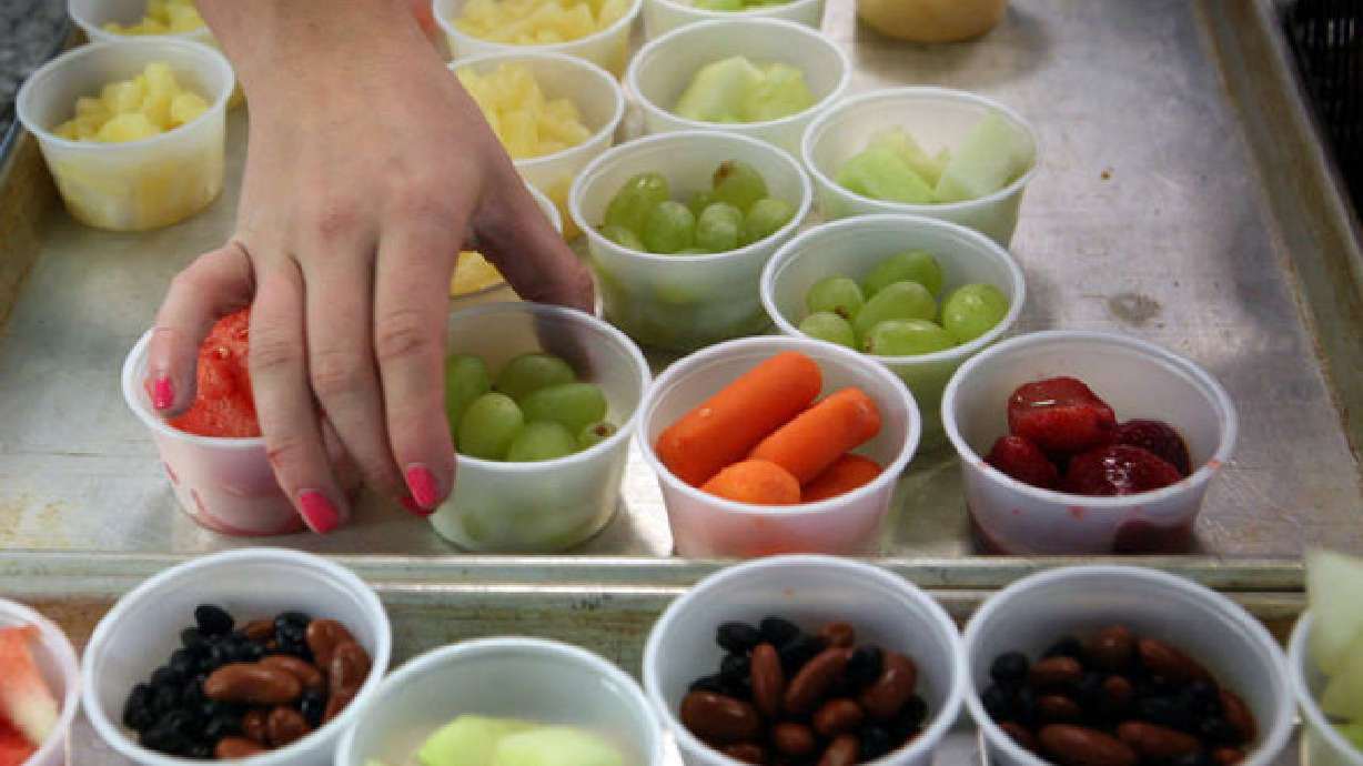 A student picks up grapes in the lunch line at Copper Hills High School in West Jordan on Sept. 27, 2012. School lunch programs around the country, including multiple schools and districts in Utah, are adapting their menus this year to account for significant shortages due to plant closings and worker shortages.
