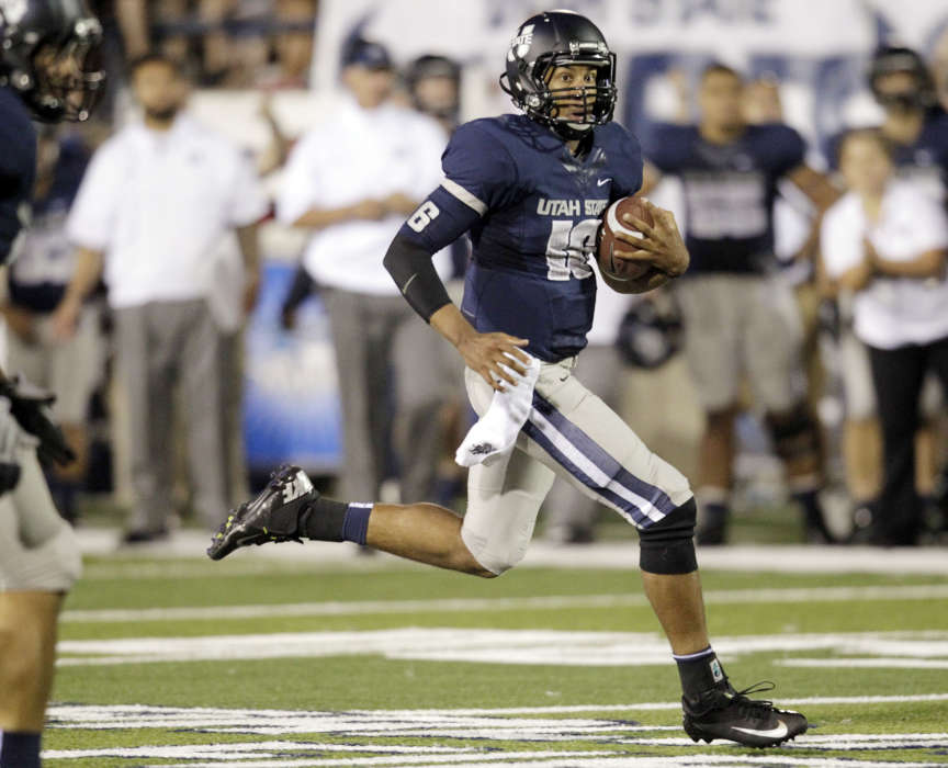 Utah State Aggies quarterback Chuckie Keeton (16) runs for 23 yards in overtime against Utah (Jeffrey D. Allred, Deseret News)