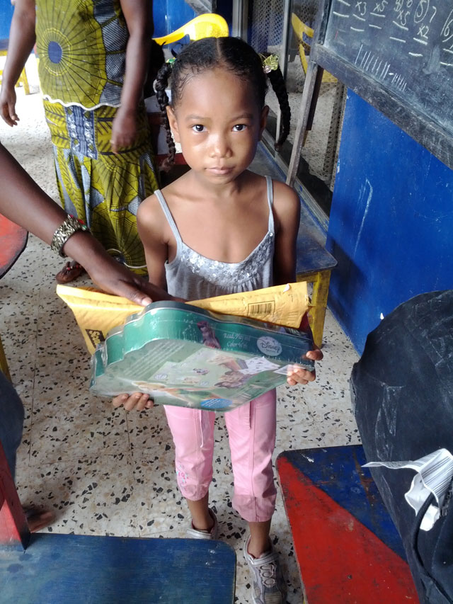 A young Liberian girl receives desperately needed educational items.